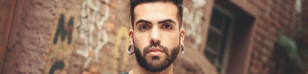 Man with stretched lobes and nostril piercing