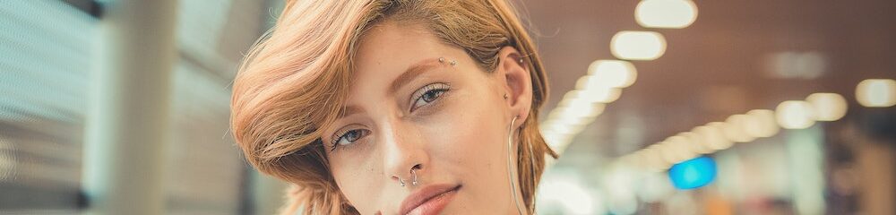 Woman with a tragus piercing, other cartilage piercings, and facial piercings