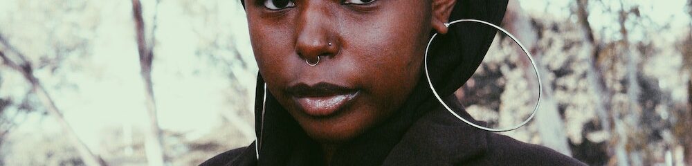 Woman with nostril, septum, and ear piercings