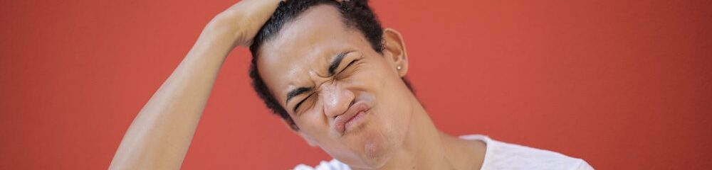 Man with ear piercing looks frustrated