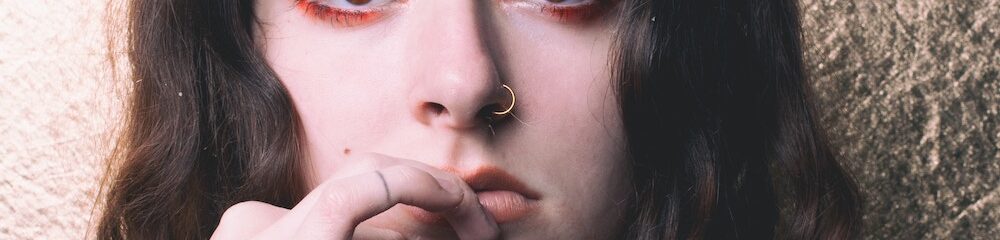 Woman with nostril piercing touching her face