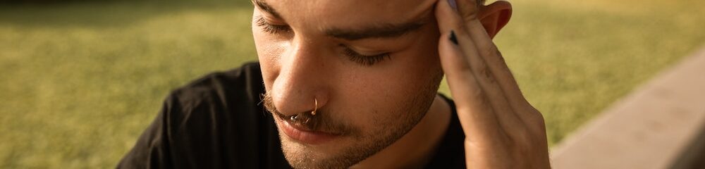 Man with nose piercings looks sad